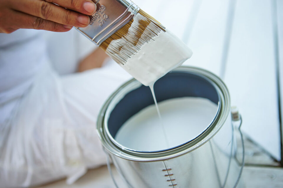 removing paint brush after dipping it into paint can