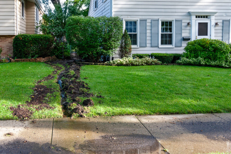 dug out trench between two homes for drainage pipes