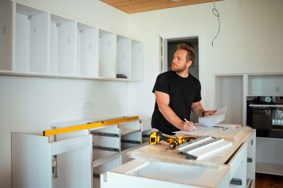 man taking notes during kitchen renovation